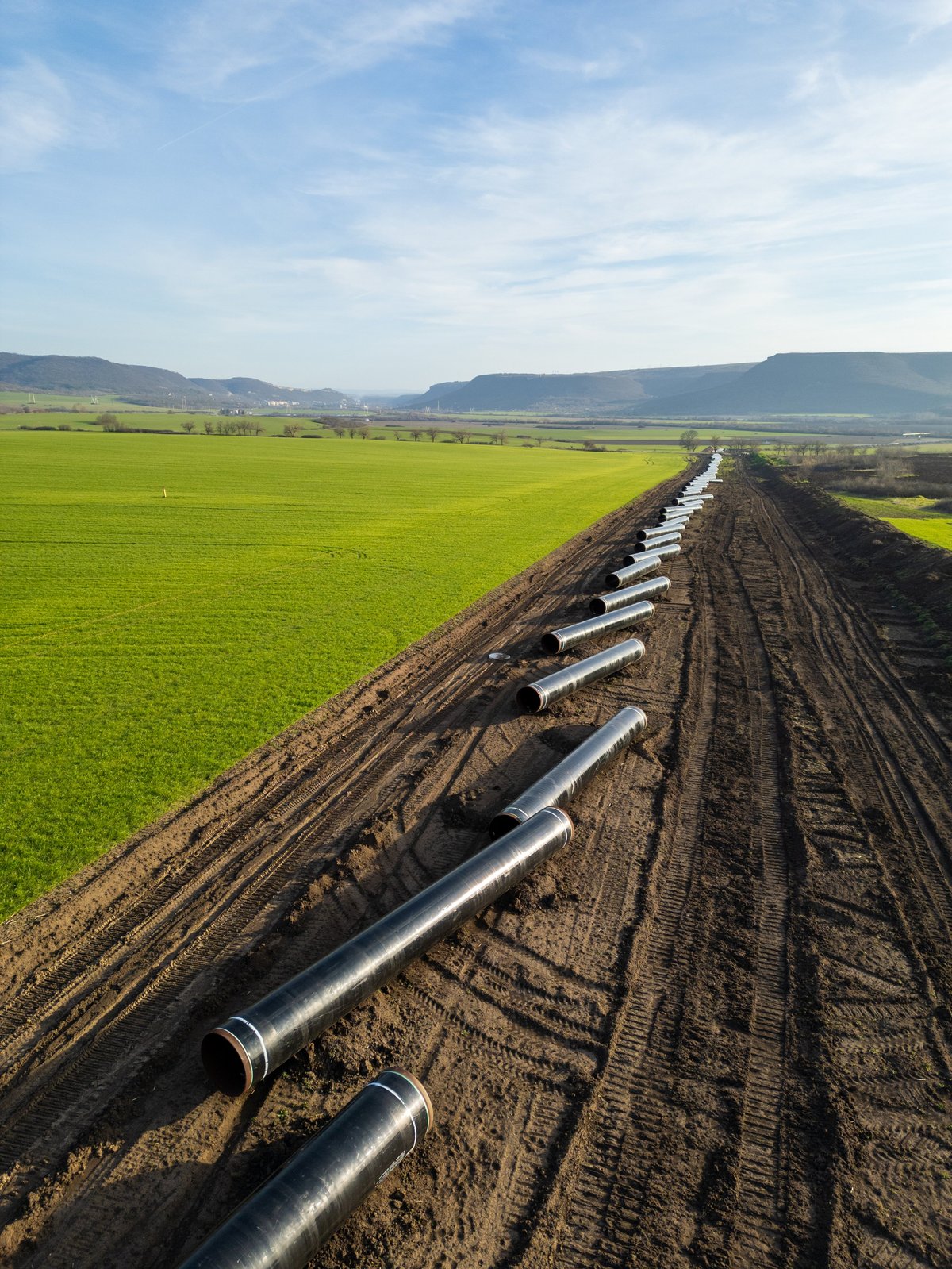 Workers and machinery installing large steel pipelines